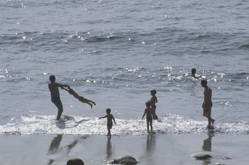 Family playing by the edge of the sea, Cot Cove, Cornwall, England, Great Britain