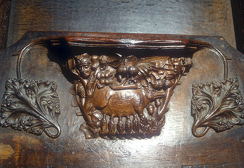 Misericord of sow suckling piglets in a wood, watched by a man, fourteenth century, Chester Cathedral, Cheshire