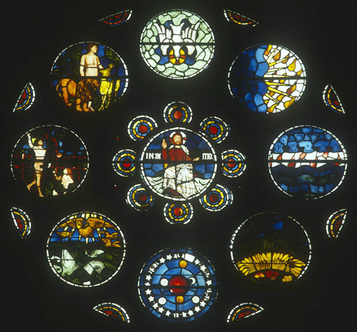Nine roundels, Christ in Majesty at centre, in West rose,  by William Morris, 1862, All Saints Church, Selsley, Gloucestershire, England