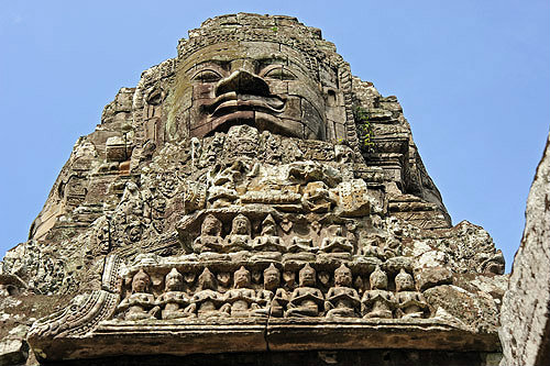 Carved face and praying figure on gopura on east side, Bayon temple, Angkor Thom, late twelfth century, Cambodia