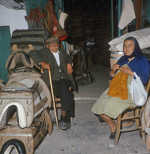 Old man and woman sitting outside a saddle shop in Kato Figalia, Aarcadia, Greece