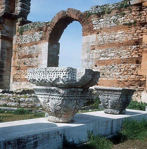 Byzantine style acanthus leaved capital, with Basilica behind showing alternate courses of brick and stone, Pbilippi, Greece