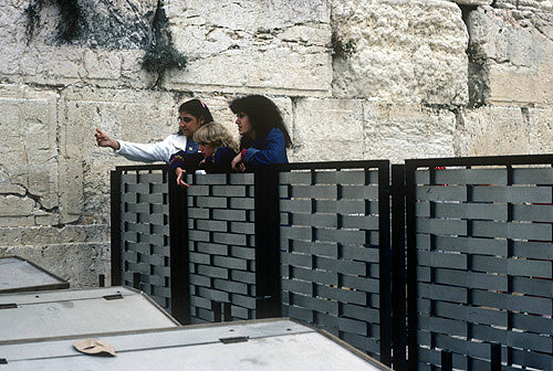 Israel, Jerusalem, the Western Wall, three Jewish girls watching the men over the dividing fence which separates them