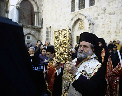Israel, Jerusalem, Greek Orthodox Priest holding a Bible outside the Holy Sepulchre Church for Maundy Thursday