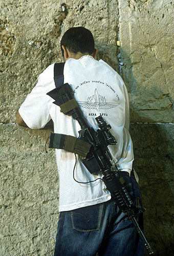Israel, Jerusalem, armed civilian praying at the Western Wall