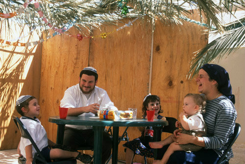Israel West Bank Kochav Hashahar Shlomo and Miriam Swickler and children at tea time in their Sukkah (tabernacle)