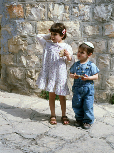 Israel Jewish boy and girl eating Maztot at Passover