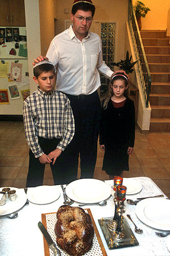 Israel, Friday Night, a Jewish father blesses his children before the Shabbat meal