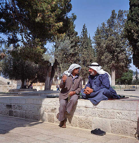 Israel, Jerusalem, two Arabs in deep conversation sitting on a wall in the Temple Area