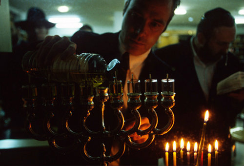 Israel Hanukkah Feast of Lights religious Jew fills Menorah with olive oil