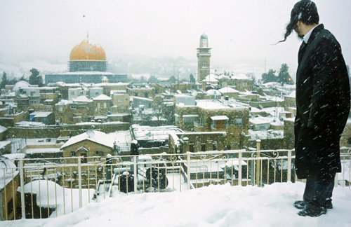 Dome of the rock under snow, observed by Orthodox Jew in the foreground, Jerusalem, Israel