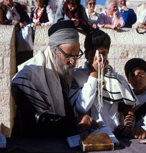 Israel Jerusalem Sephardic Rabbi and a boy kissing the prayer shawl