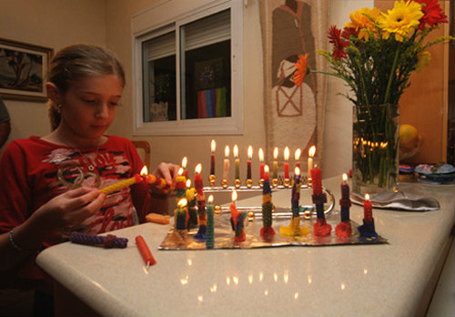 Israel Hanukkah girl lighting Menorah on the eighth day
