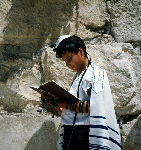 Israel Jerusalem Sephardic Jewish boy reading his prayer by the Western Wall at his Bar mitzvah