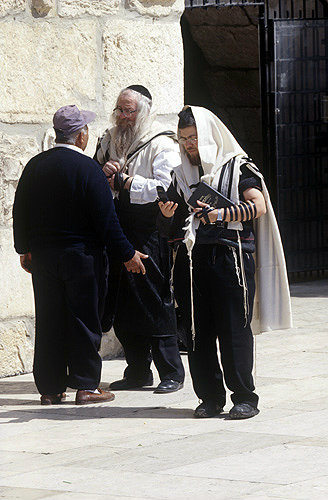 Israel, Jerusalem, two Orthodox Jews and a tourist at the Western Wall