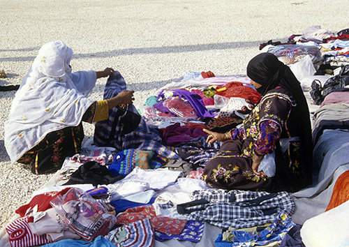 Bedouin woman in embroidered dress selling clothes, Bedouin market, Beersheva, Israel
