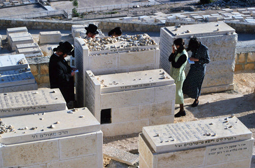 Israel Jerusalem Orthodox Jews pray at a grave in Jewish Cemetery on the Mount of Olives