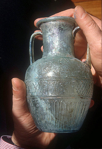 Shlomo Moussaieff holding first century AD glass amphora, signed by Ennion, about 8 inches high, dug up inside the city walls of Jerusalem, Israel