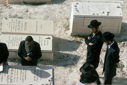 Israel Jerusalem strict Orthodox Jews around grave in cemetery on the Mount of Olives