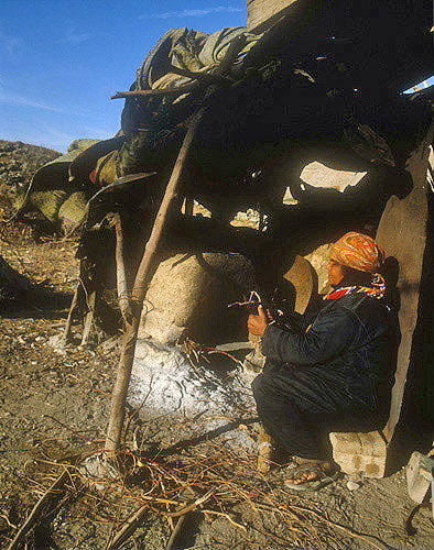 Bedouin woman preparing fire in clay oven
