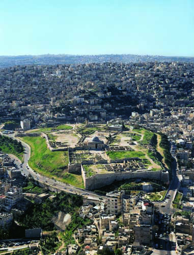 North end of the L-shaped Citadel, with Bronze and Iron Age walls, eighth century Umayyad complex, surrounded by modern city, aerial, Amman, Jordan