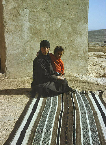 Bedouin woman and child, on woven rug, Bani Hamida, Jordan