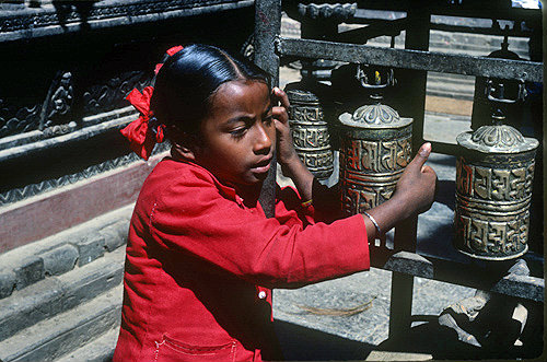 Girl turning prayer wheels, Patan, Nepal