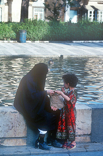 Syria, Damascus, woman and child by pool of the Tekkiye Mosque