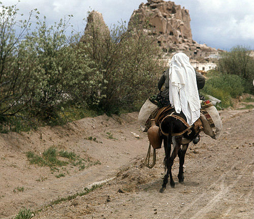 Turkey, Cappadocia,  peasant woman returning from the fields, Ushisar is in the background