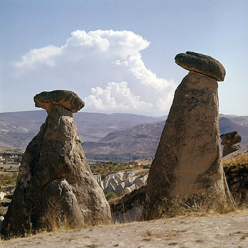 Turkey, Cappadocia, on the road between Urgup and  the Goreme Valley, two eroded Tufa Cones capped with hard rock