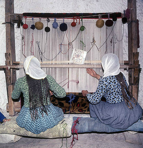Girls working at a loom in a cone dwelling, Cappadocia, Turkey