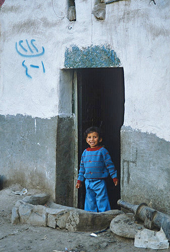 Child in doorway of house, Sana
