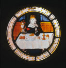 Labours of the months, King feasting, possibly December,  from Brandiston Hall Norfolk 16th century stained glass now in the Norwich Castle Museum and Art Gallery