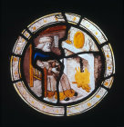 Labours of the months, elderly man sitting in front of a fire, possibly February,  from Brandiston Hall Norfolk 16th century stained glass  roundel by Norwich School now in the Victoria and Albert Museum ca 1500