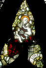 Love, one of three theological virtues, by Powell, nineteenth century, shown as woman with children, tracery of window 3, south nave aisle, Exeter Cathedral, EnglandEngland