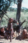 Bushmen boy Gae-tebe dancing and women clapping, Kalahari, Southern Africa