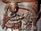 Misericord of labour of month of December, man warming himself by a fire, fifteenth century, Church of La Trinite, Vendome, France