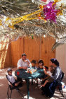 Israel West Bank Kochav Hashahar Shlomo and Miriam Swickler and children at tea time in their Sukkah (tabernacle)
