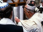 Israel Jerusalem Bar Mitzvah ceremony, the man is touching the Torah with the fringe of his shawl