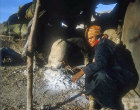 Woman preparing fire in clay oven, Jordan
