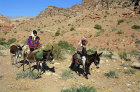 bedouin family riding donkeys through Wadi Sabra, Jordan