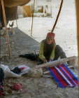 Bedouin woman weaving rug in her tent near Petra, Jordan