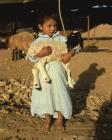 Bedouin boy outside tent holding a lamb, Jordan