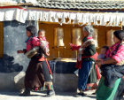 Tibet, women ringing prayer wheels