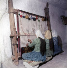 Three girls working at a loom in a cone dwelling, Cappadocia, Turkey